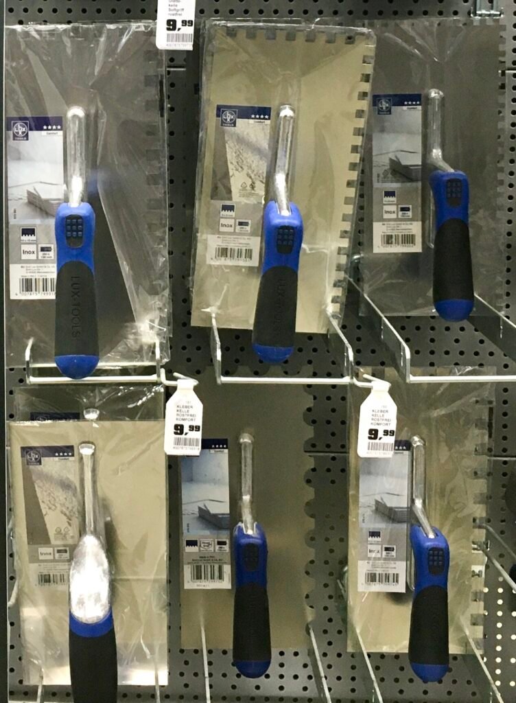 Notched trowels used to spread tile adhesive evenly on a substrate